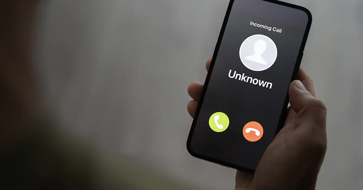 image of person looking down at their cellphone to an unknown caller