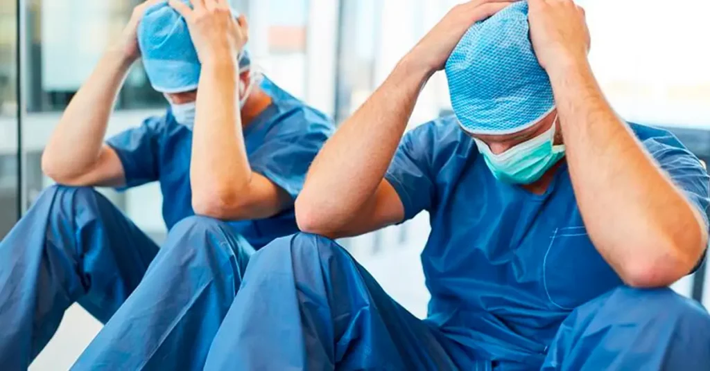Two surgeons hold their hands over their head in disgust