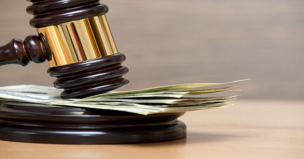 Gavel slamming on top of a stack of dollar bills