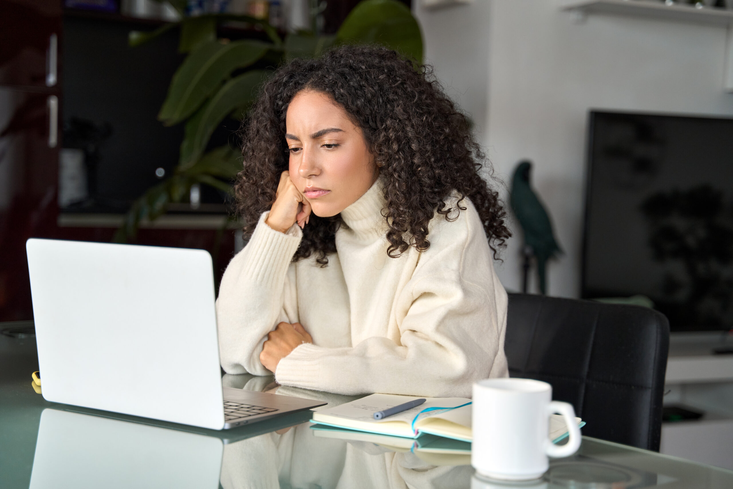 Woman looking bothered by what she sees on a laptop screen