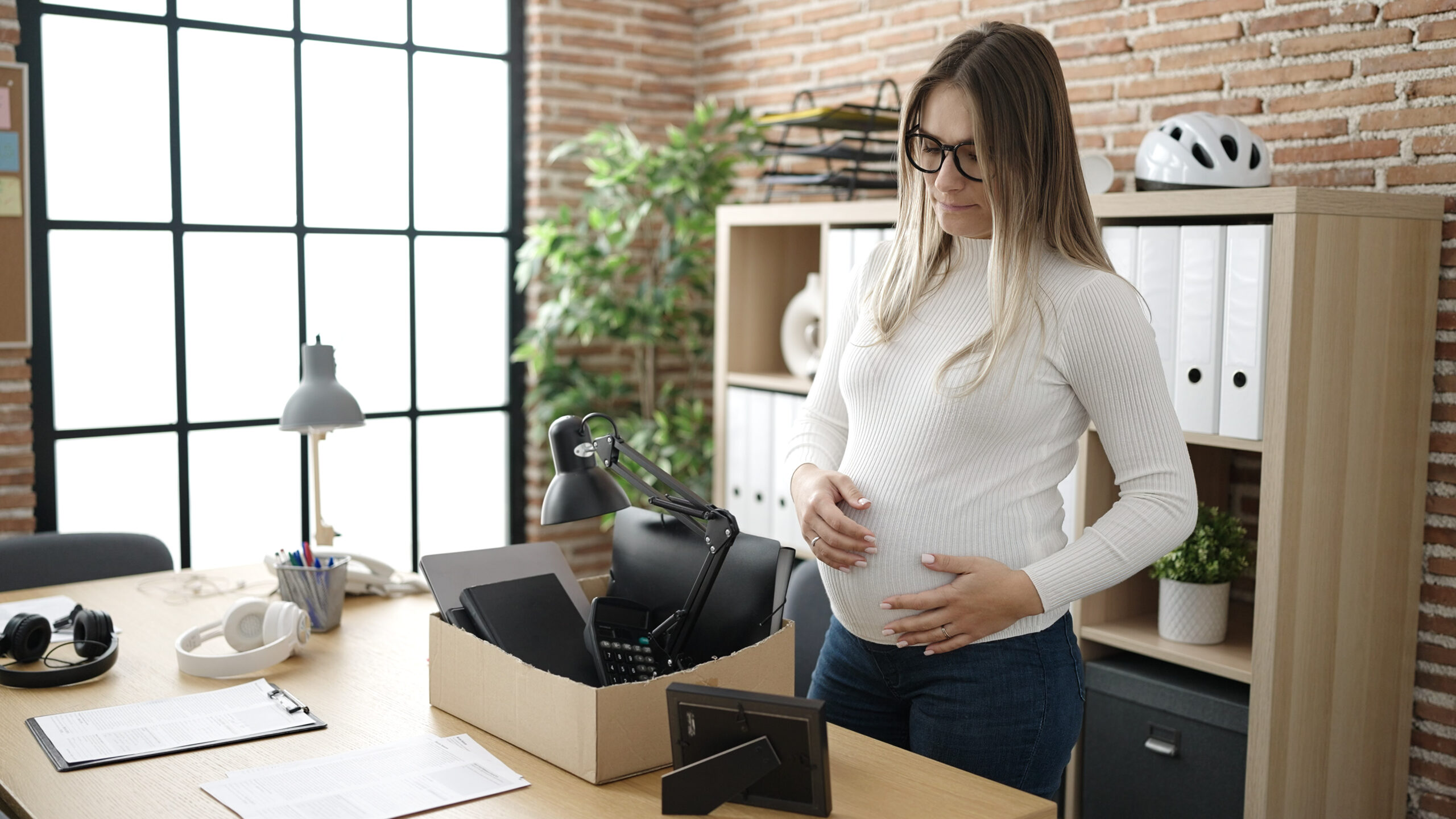 Pregnant woman packing up her things after a wrongful termination