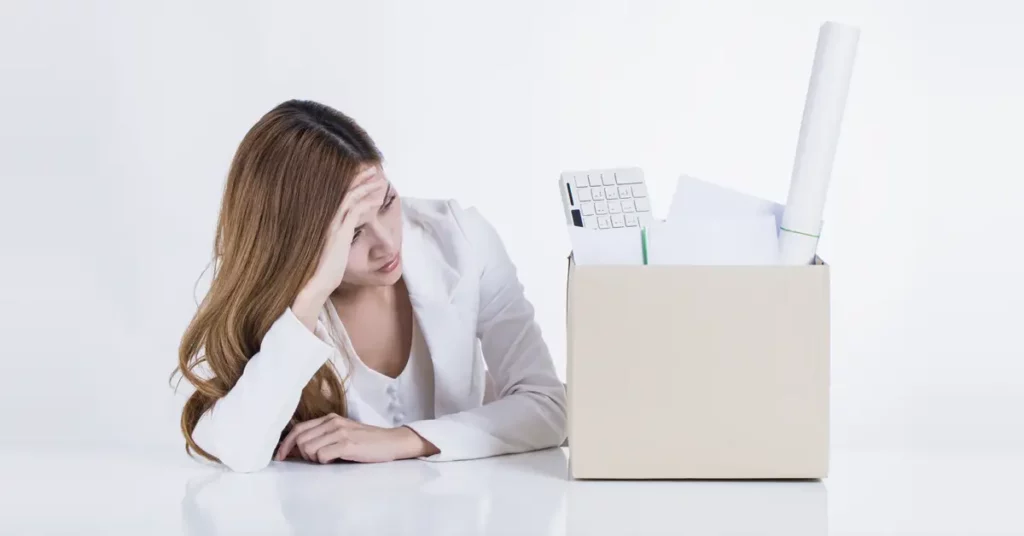 woman in distress staring at a box of her work items after a wrongful termination