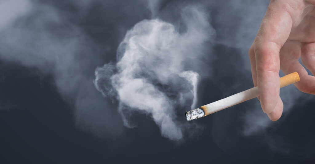 hand holding a lit cigarette