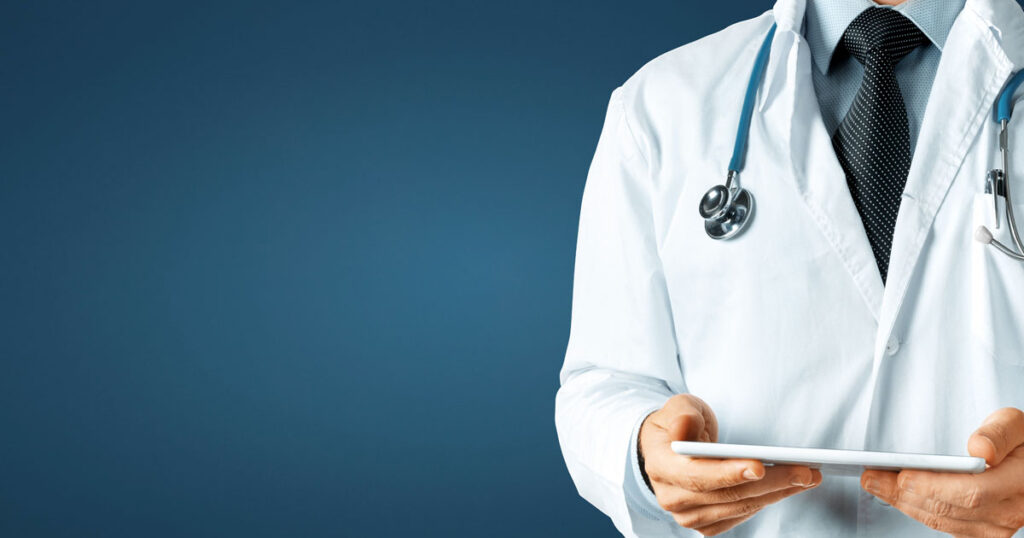 image of a doctor in lab coat holding a tablet