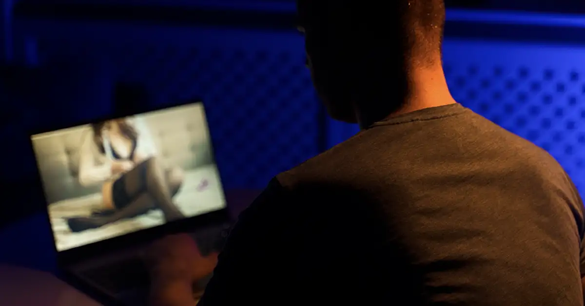 image of a man watching pornography in the dark