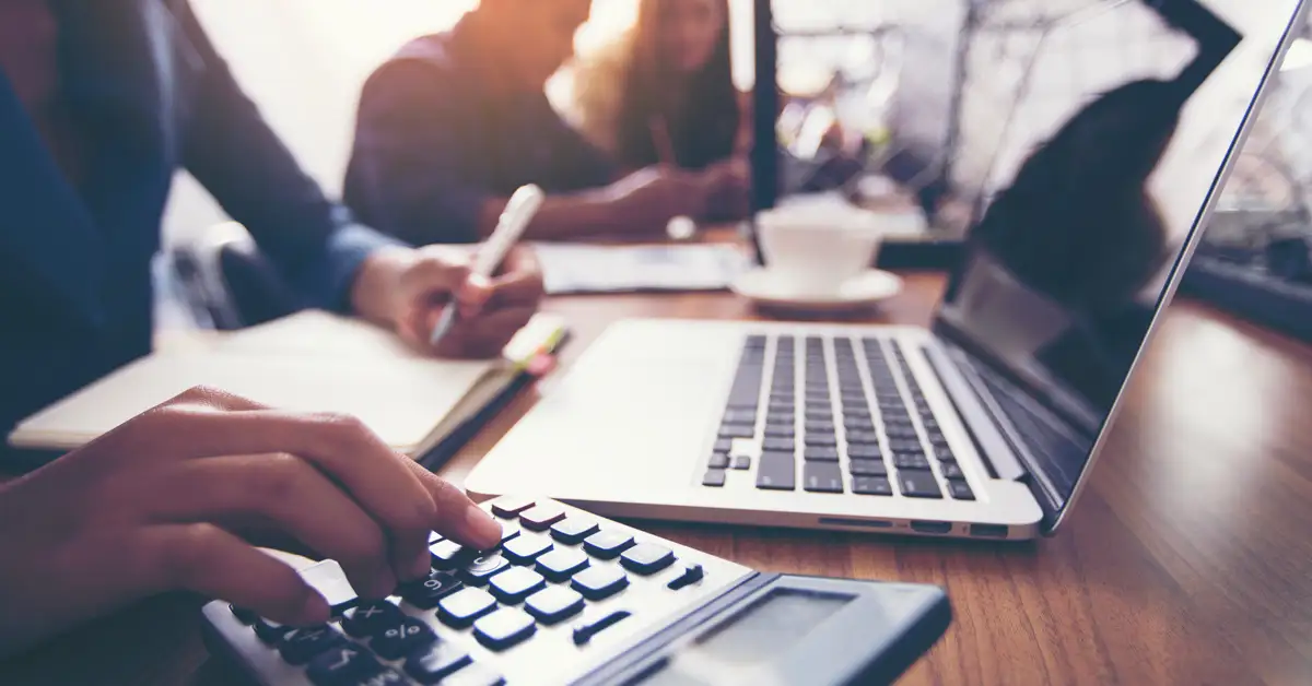 image of people at a formal bank desk with computer and calculator