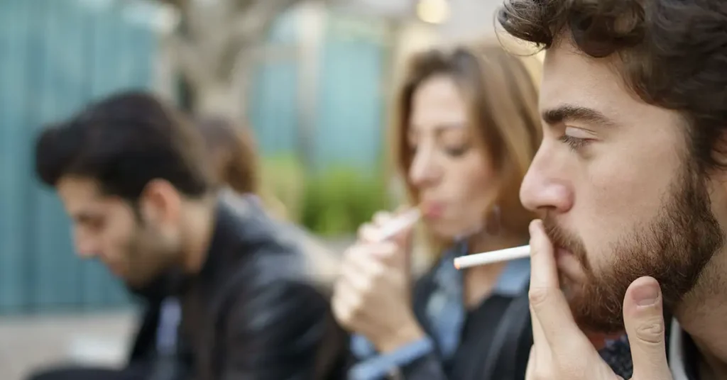 image of young adults smoking outside